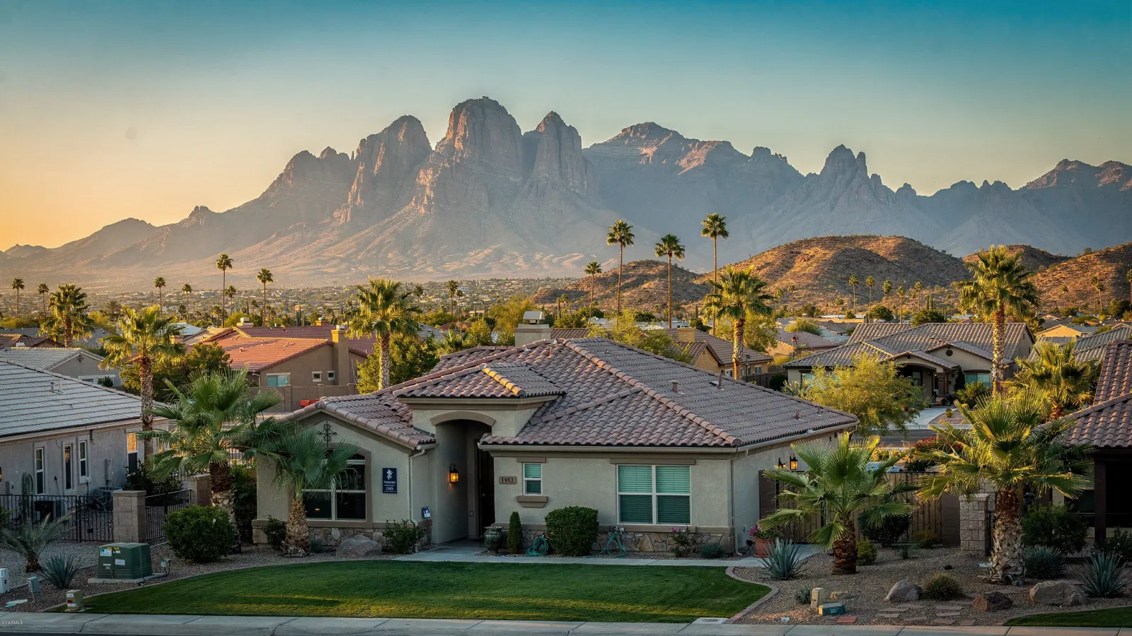 East Valley neighborhood of tile-roof desert homes with the Superstition Mountains rising at sunrise
