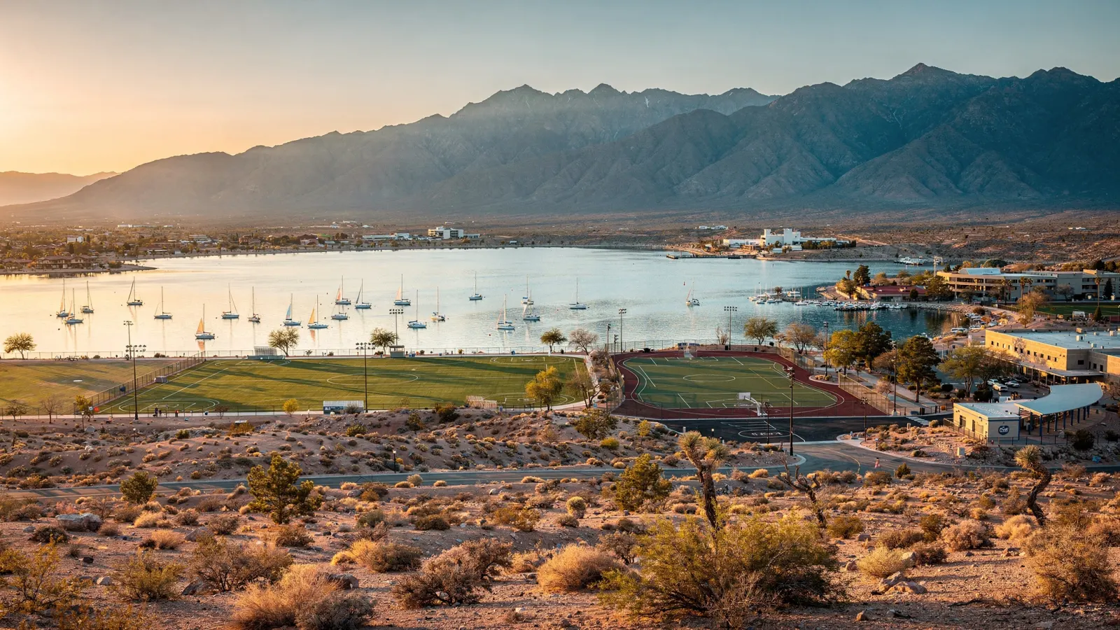 Peoria Arizona lake park with sailboats, sports fields and desert mountains at sunset