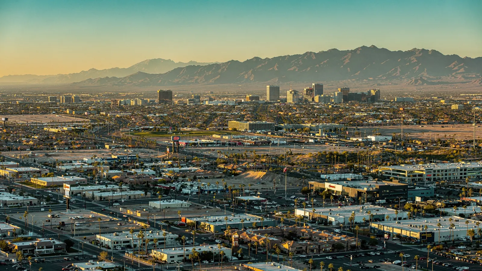 Aerial view of the Phoenix metro area at golden hour with desert mountains